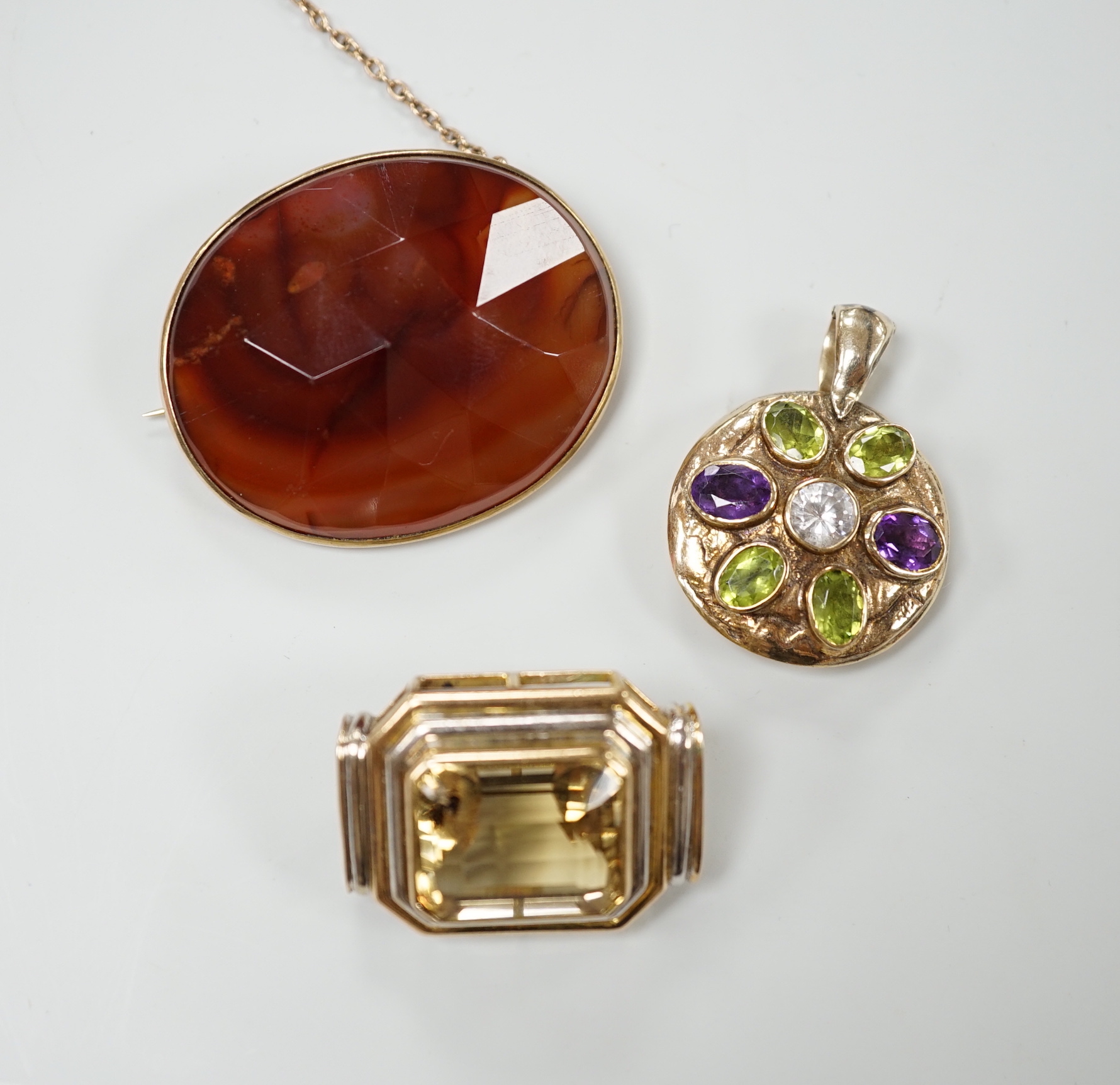 A modern 9ct gold, peridot, amethyst and simulated diamond cluster set circular pendant, diameter 27mm, together with a 9k and citrine set brooch and a yellow metal and facetted agate set brooch.